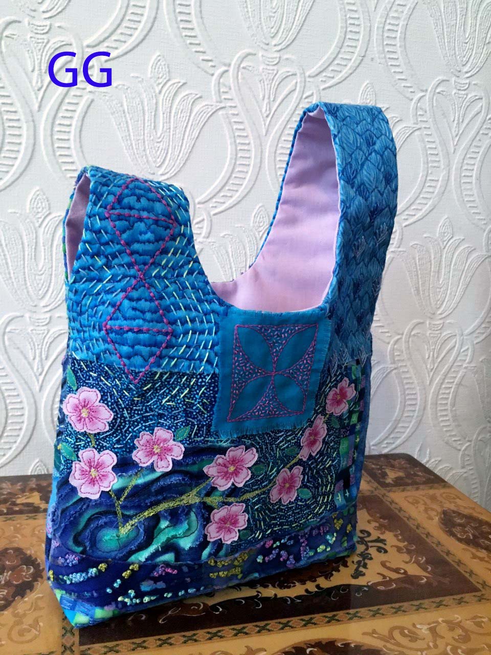 (back view)JAPANESE KNOT BAG, made using the Boro technique of applying patches with hand and machine embroidery. The chrysanthemum and cherry blossom were machine stitched and hand painted, Aurifil competition 2021