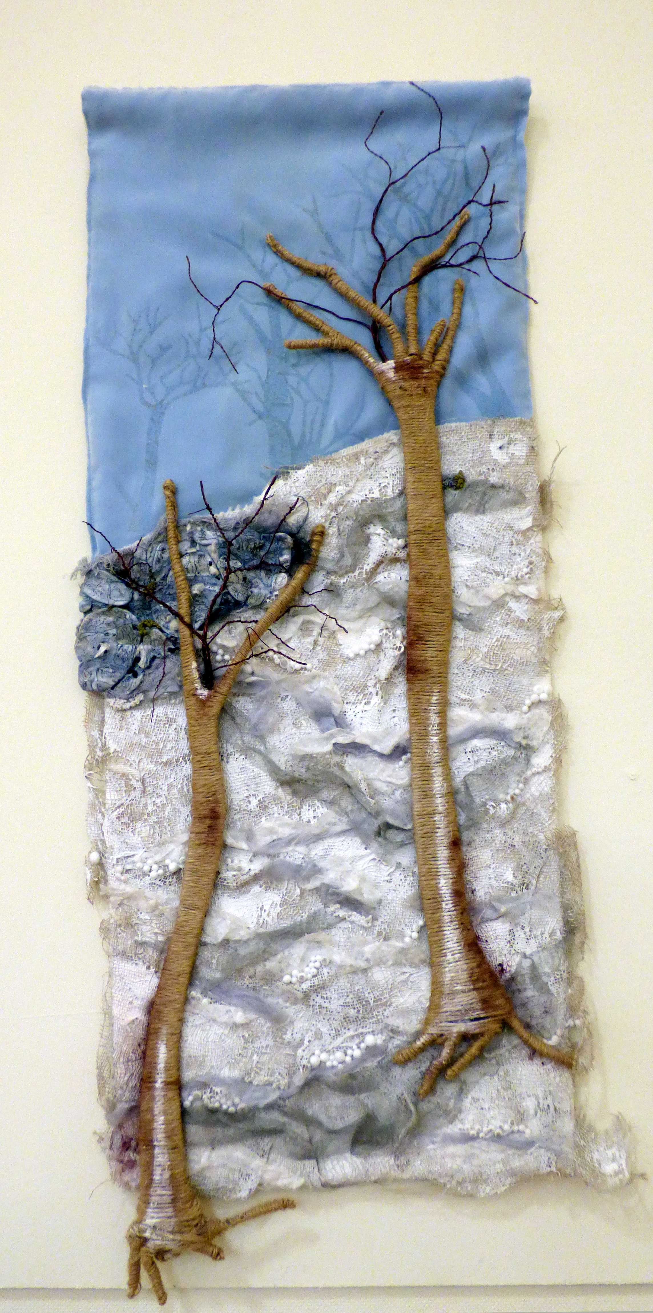 TREES IN A DERBYSHIRE LANDSCAPE by Judi Brown, Glossop & District EG, mixed media with woven silver, wire, gesso and Tyvek