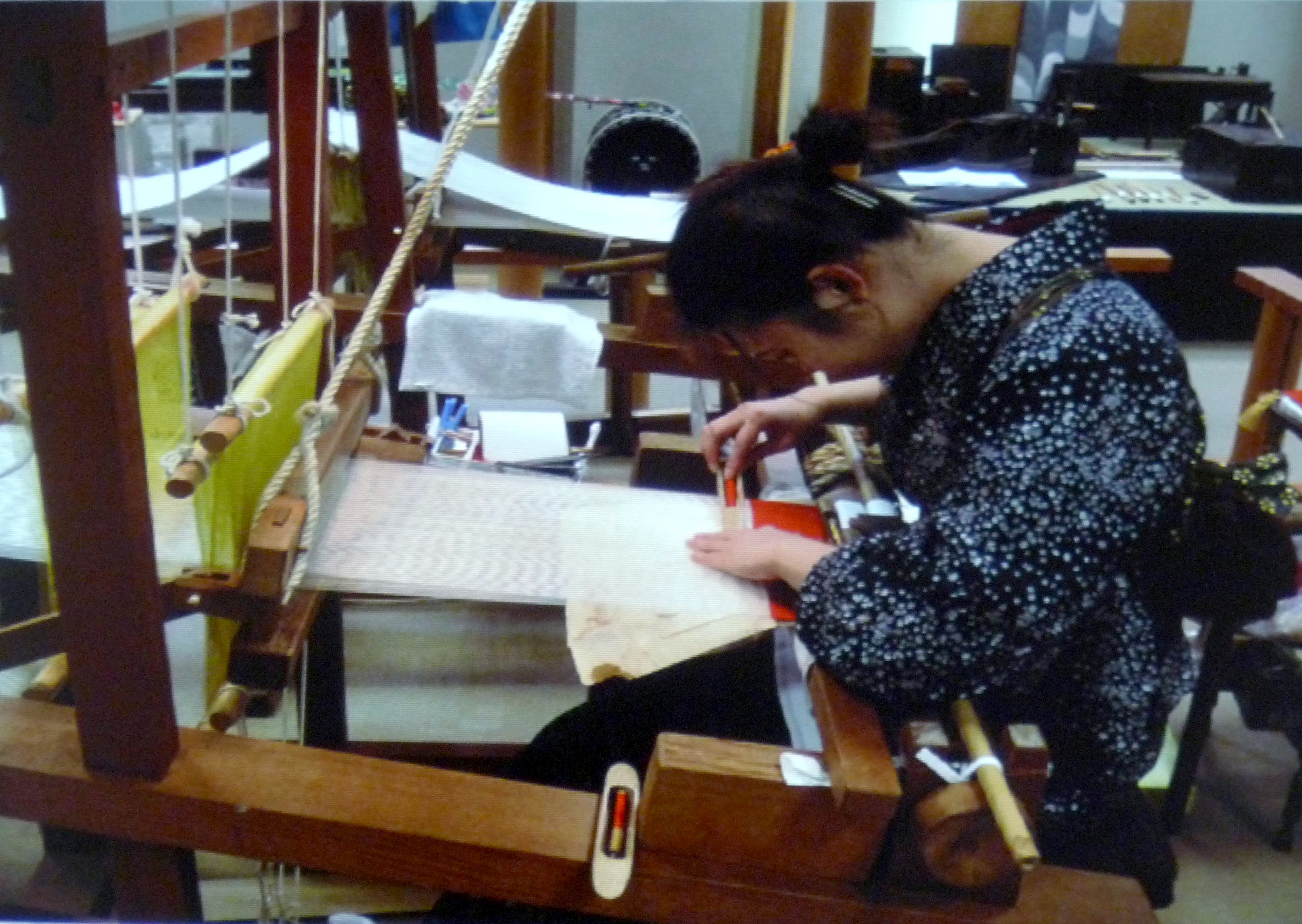 Katie Chaplin slide showing a Japanese weaver hand weaving silk fabfic