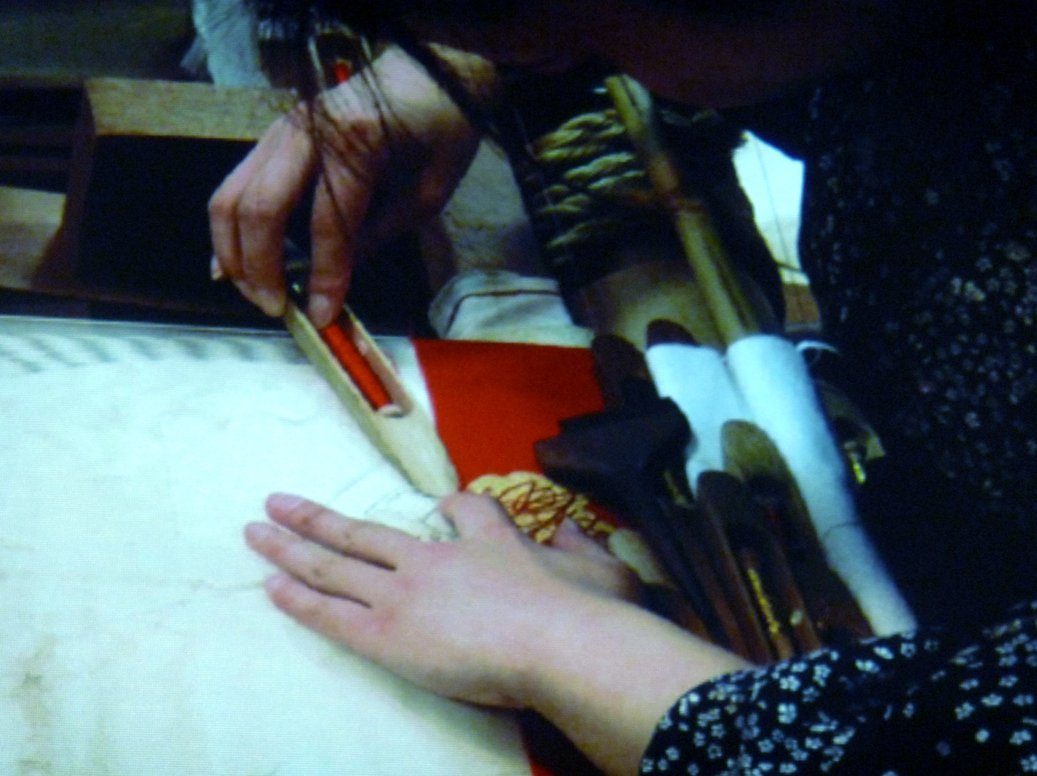 detail of Katie Chaplin slide showing a Japanese weaver hand weaving silk fabfic