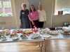 Kim, Patti and Olive preparing the lunch table for Merseyside Expressive Stitchers' Group shared lunch, October 2023
