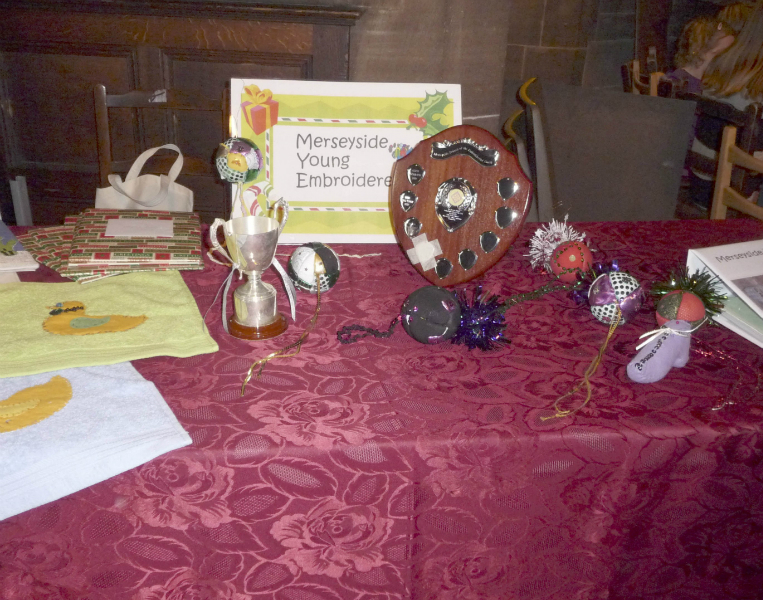 the Young Embroiderers\' table with the Cup and Shield for the YE member who has made the most improvement during the year
