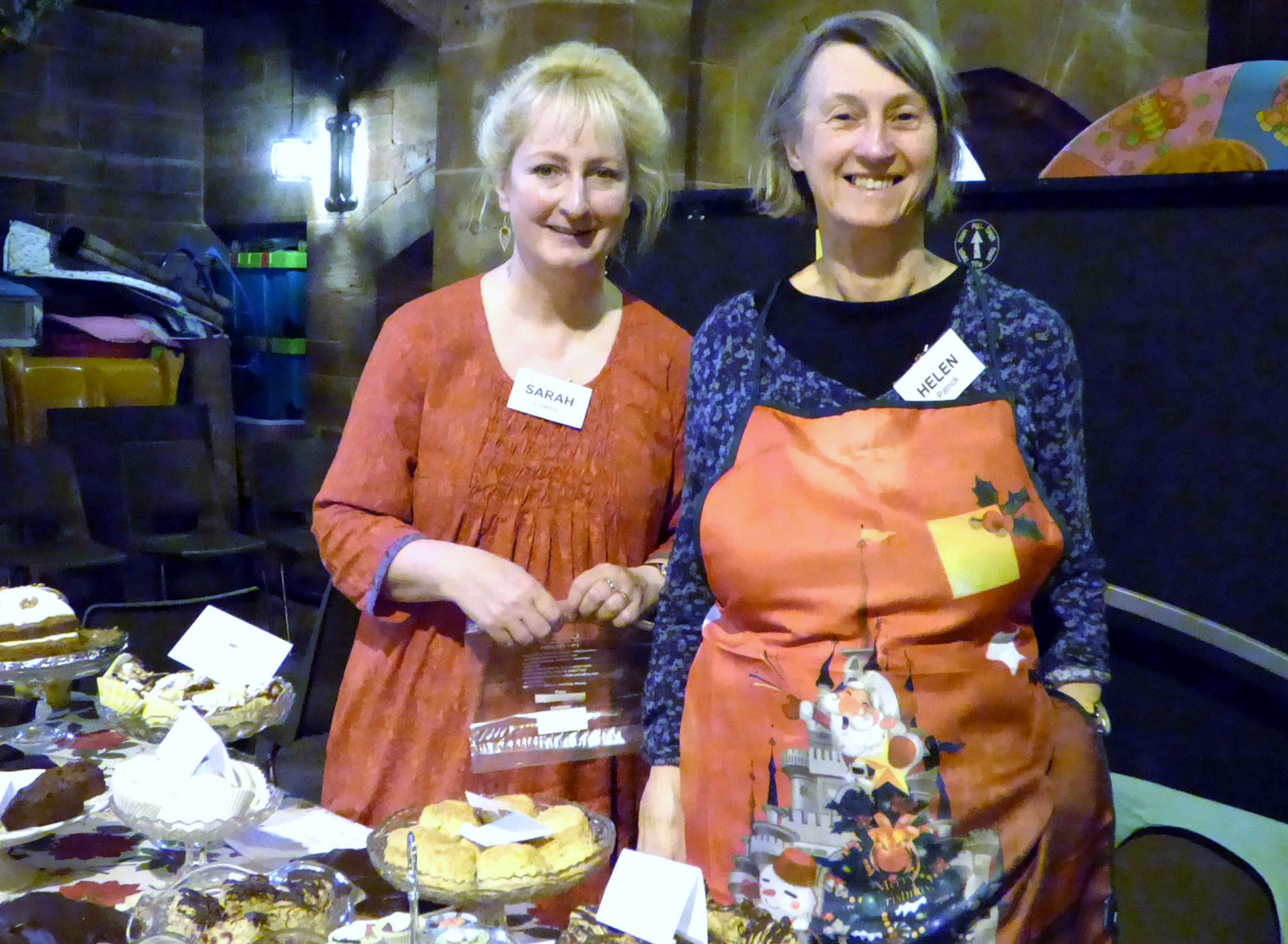 Sarah and Helen ready to welcome customers at the homemade cake stall, MEG Christmas Party 2017