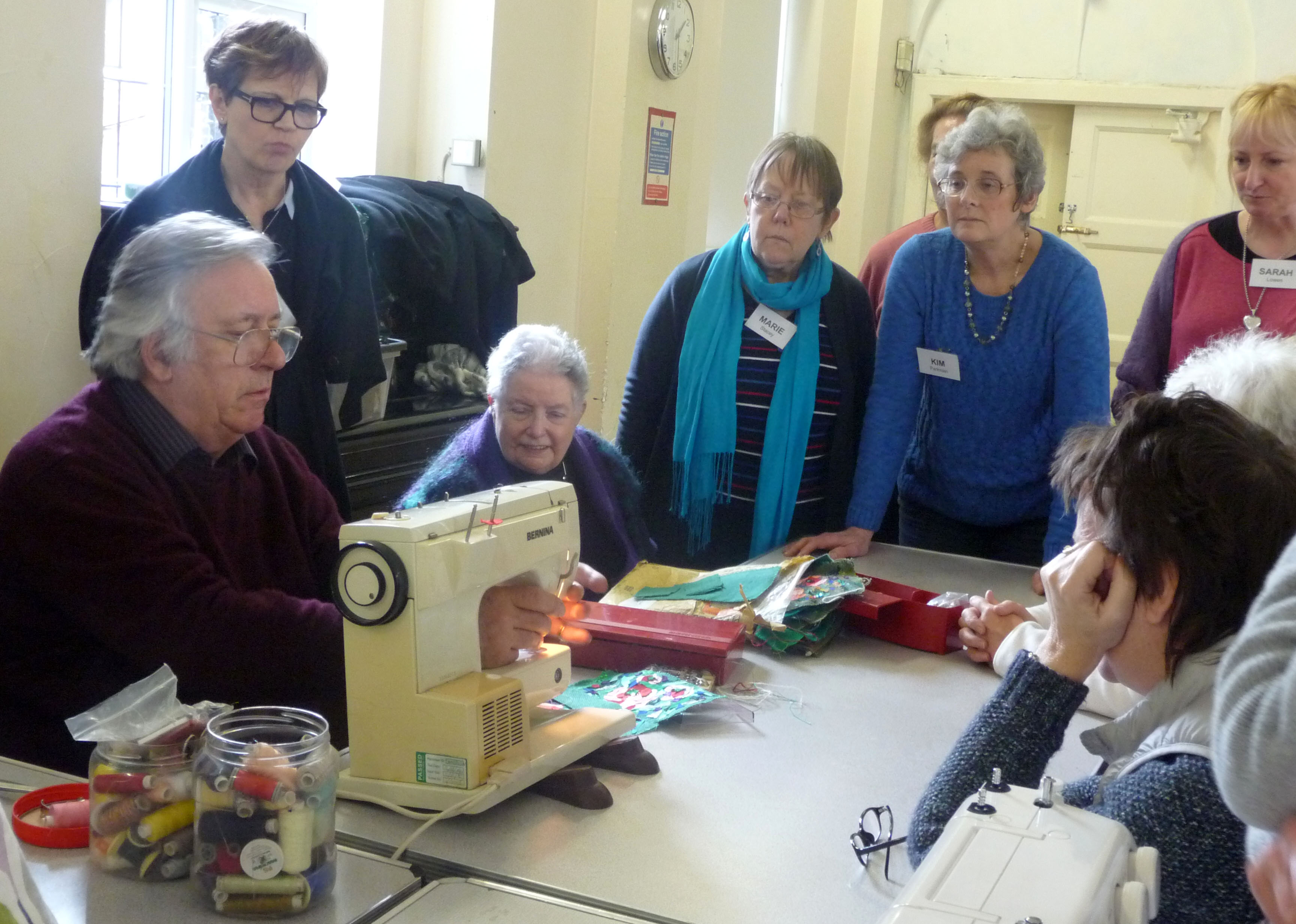 Richard Box is demonstrating how to stitch the poppy collage