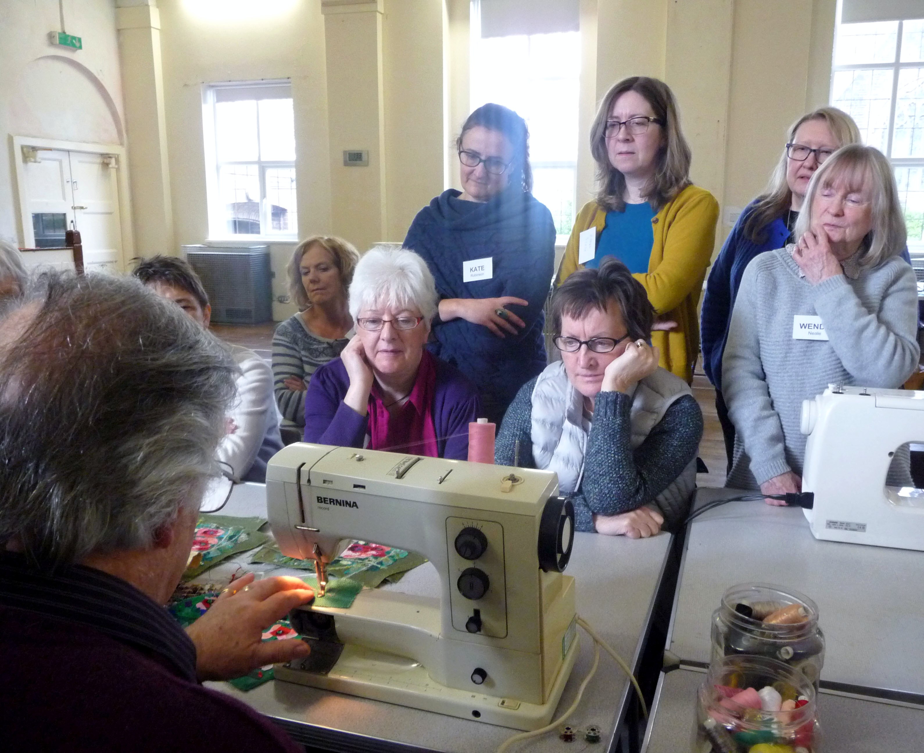 Richard Box is demonstrating how to stitch the poppy collage