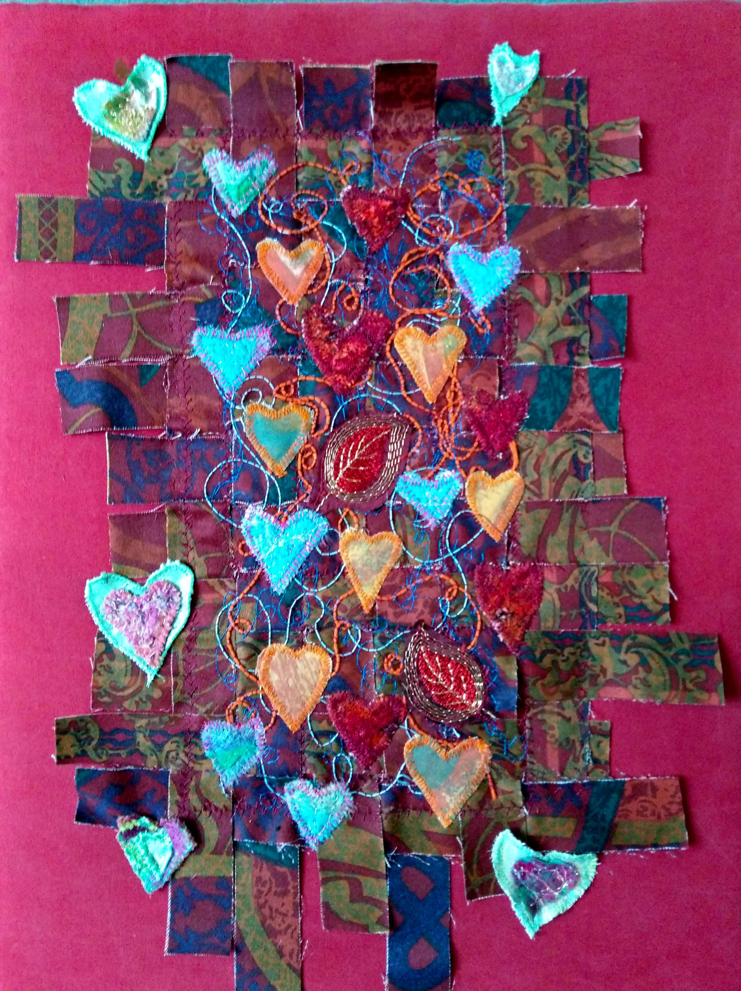 INTERWOVEN LOVE by Sheila Conchie, Glossop branch, woven strips of fabric, machined at random with added machine embroidery and applique hearts, Rose Bowl competition 2021