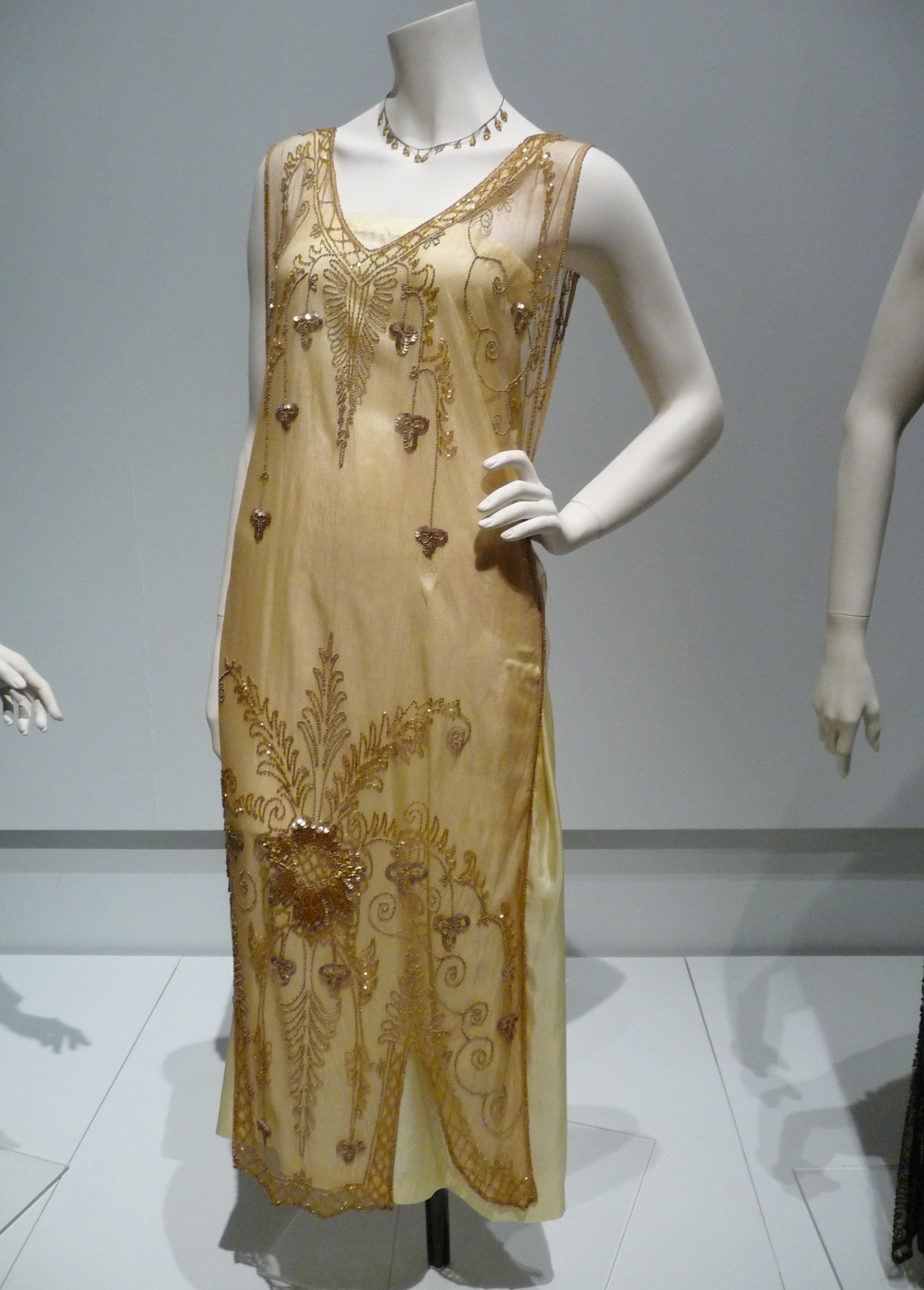 TUNIC-STYLE EVENING DRESS, silk net embroidered with sequins and glass bugle beads, reproduction silk under-slip, circa 1920-24.