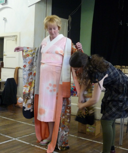 Katie is adjusting the under garment to fit inside the kimono sleeves