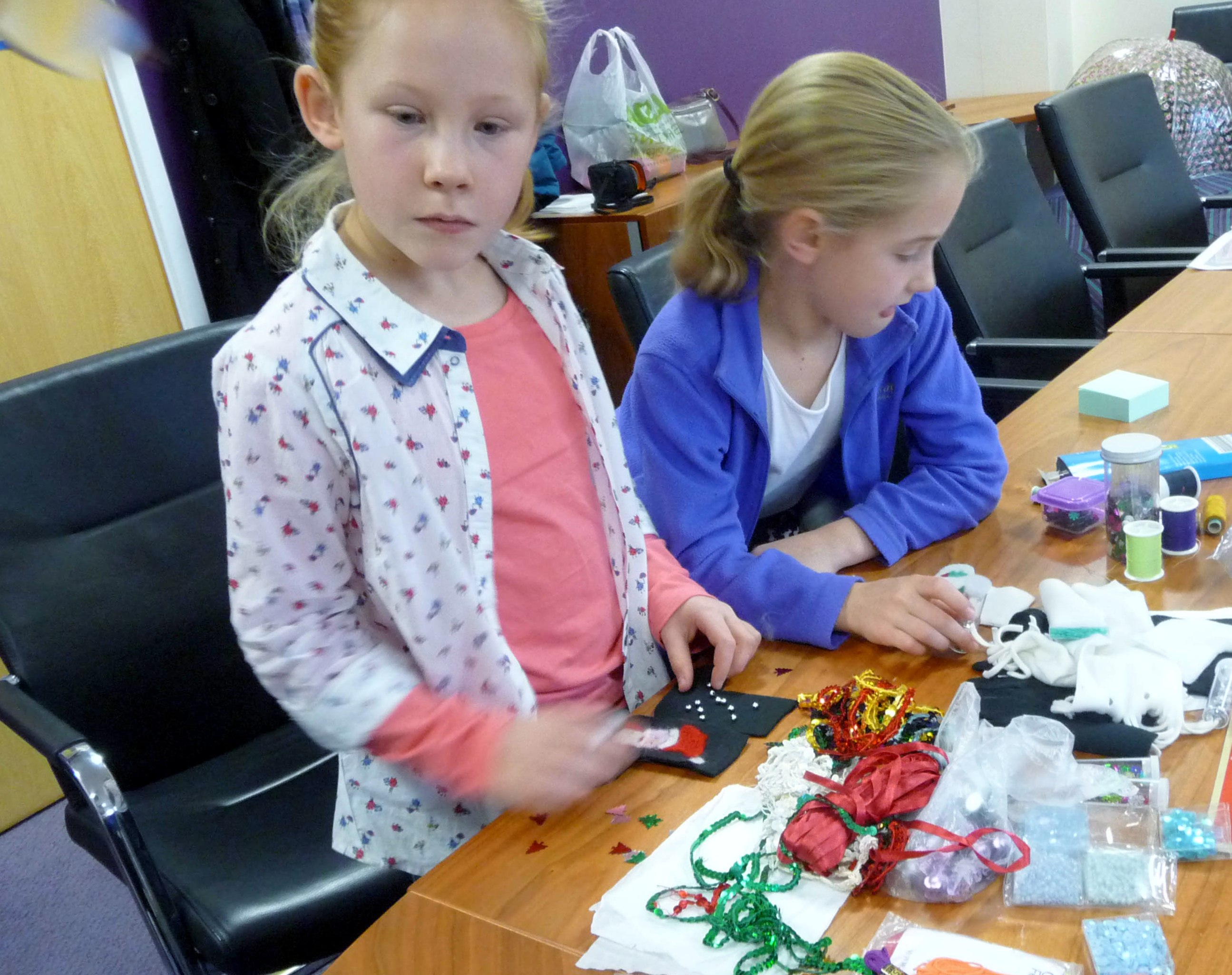 Zoe and Emma are choosing some embellishments for their needle-felted Christmas stockings
